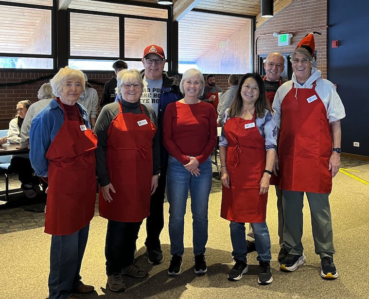 Arapahoe Santa Claus Shop volunteers wearing red aprons.