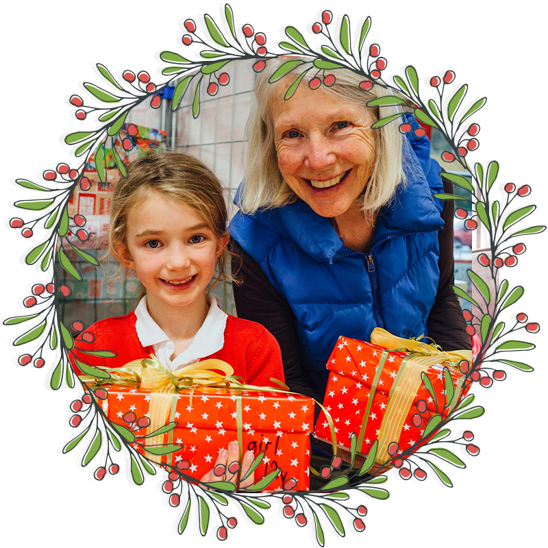 Volunteer smiling with a child while gifting a toy